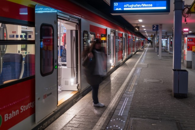 Person getting off the S-Bahn and crossing the illuminated platform edge which shows the occupancy of the train.