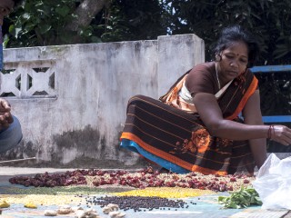 Meena trocknet die Gewürze für ihr Curry auf dem Hausdach, um den Geschmack zu verbessern